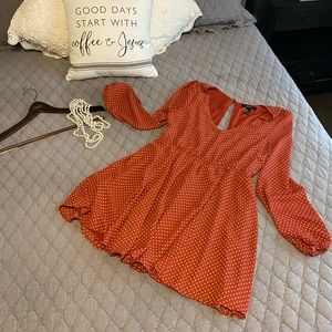 This is a mini burnt orange dress with white polka dots. Open back.